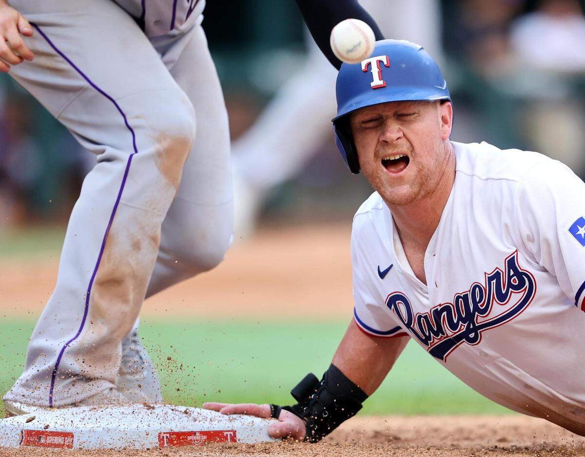 Texas Rangers right fielder Kole Calhoun reacts after being hit by the ball in a missed pickoff attempt on Monday, April 11, 2022, at Globe Life Field.