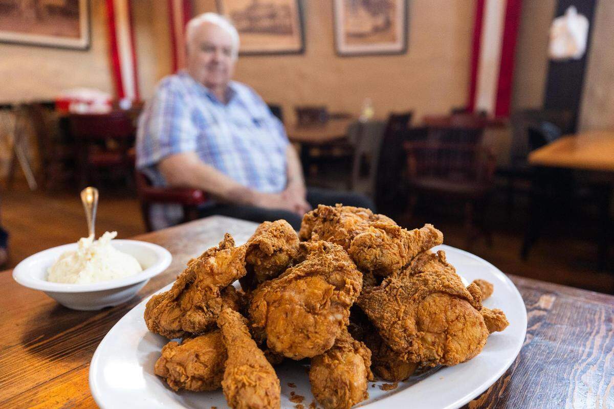Paul Vinyard of Babe’s Chicken sits by a fried chicken platter in the North Richland Hills location.