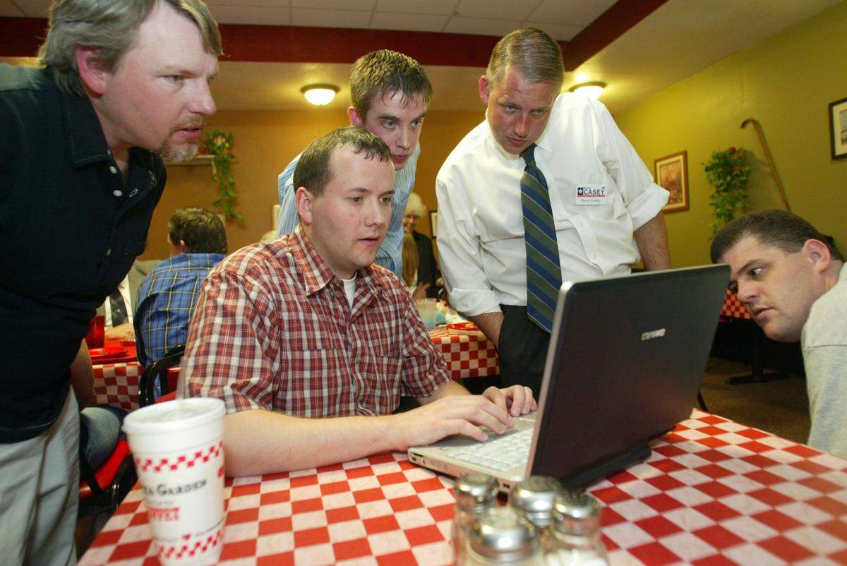 April 11, 2006: Russ Casey, Republican candidate for Justice of the Peace, Precinct 3, second from right, looks at election night results with brother, Gene Casey, far left, and supporters Dustin Henry, Conan Saunders and Monty Leverett at the Pizza Garden Restaurant in Bedford.