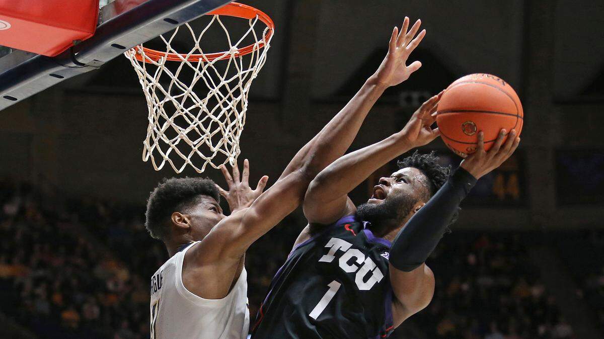 TCU guard Mike Miles Jr. (1) is defended by West Virginia forward Mohamed Wague during the first half of an NCAA college basketball game Wednesday in Morgantown, W.Va.
