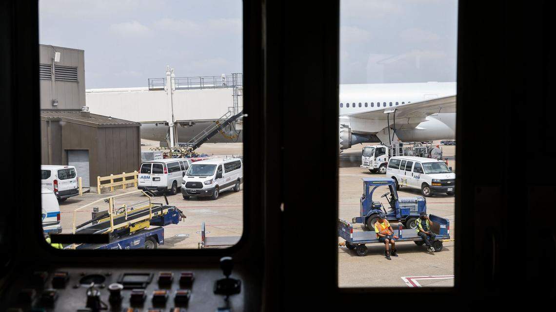 Members of the ground crew is seen through a boarding bridge as they await for an American Airlines flight on May 9, 2023, at DFW Airport. (Shafkat Anowar/The Dallas Morning News/TNS)