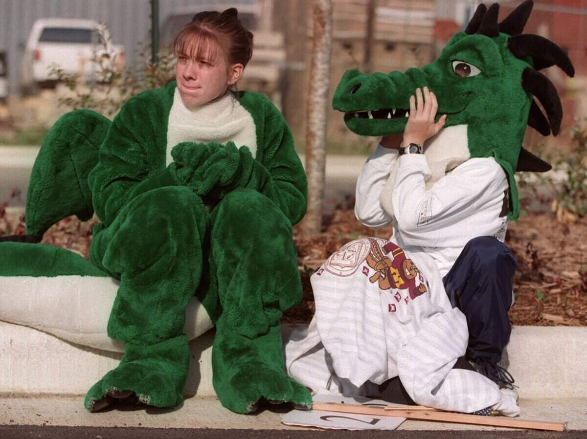 March 20, 1999: The Southlake Carroll Dragon mascot appears to wonder how his head got onto a human's body as Derek Whightsil, 11, left, tries on his 16-year-old sister Jennifer Mead's costume while the two were waiting for the Southlake Town Square grand opening parade to begin.