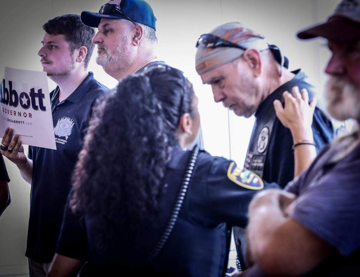 Ron Warren (in cap) stands in the background as Mineral Wells police have a word with another attendee at the Beto O’Rourke rally.