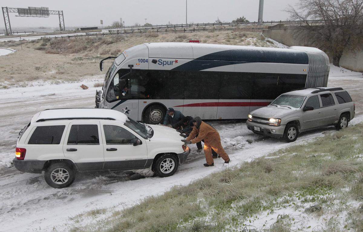 Motorists try to get vehicles and a city bus up an icy hill on East Lancaster Avenue in Fort Worth on Friday, Dec. 6, 2013.