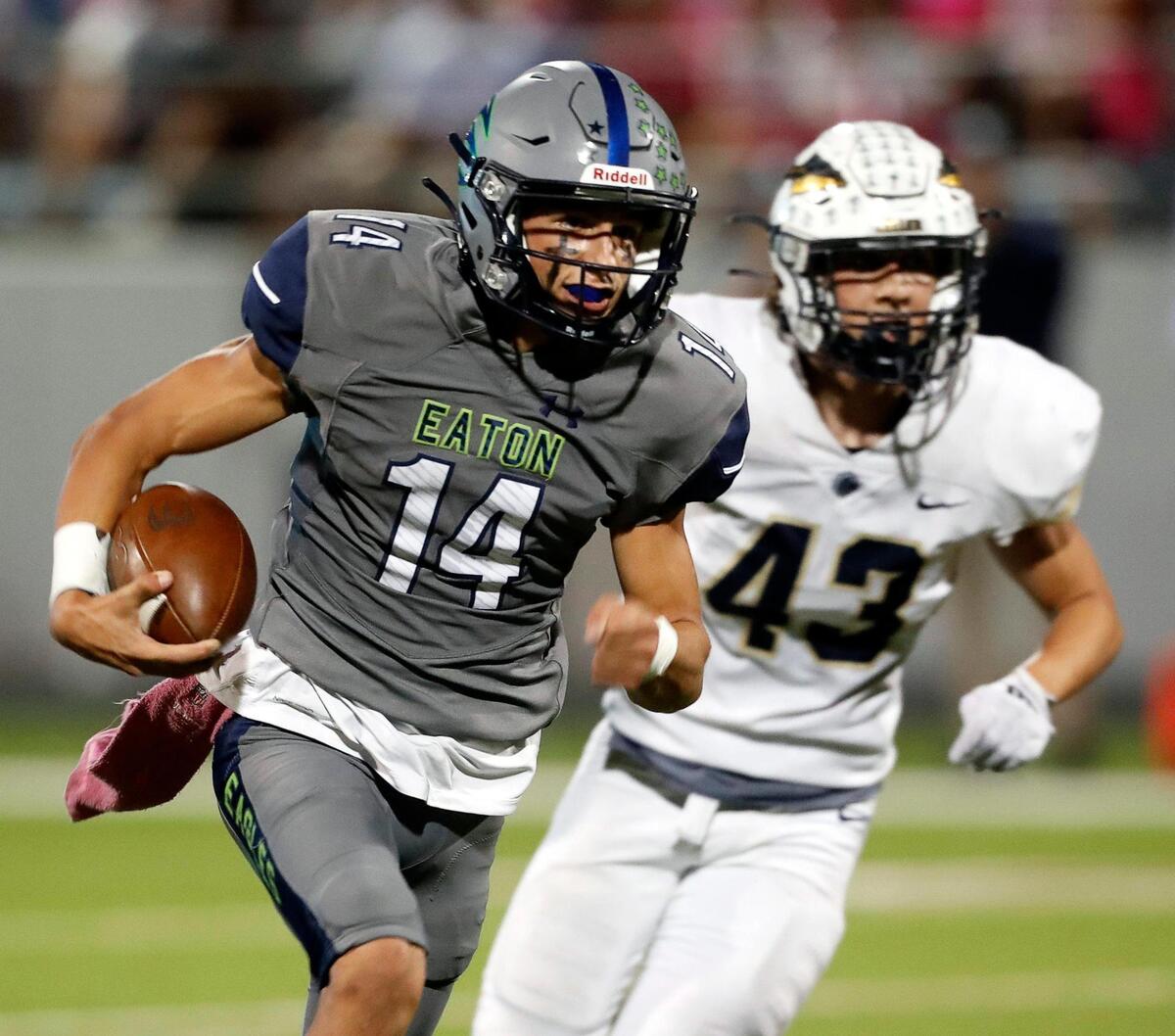 Eaton quarterback Noah Lugo (14) outruns Keller defensive lineman Jackson Taylor (43) to the end zone for a touchdown in a high school district 4-6A football game at NWISD Stadium in Justin, Texas, Friday Oct. 08, 2021. Eaton defeated Keller 43-21. (Special to the Star-Telegram Bob Booth)