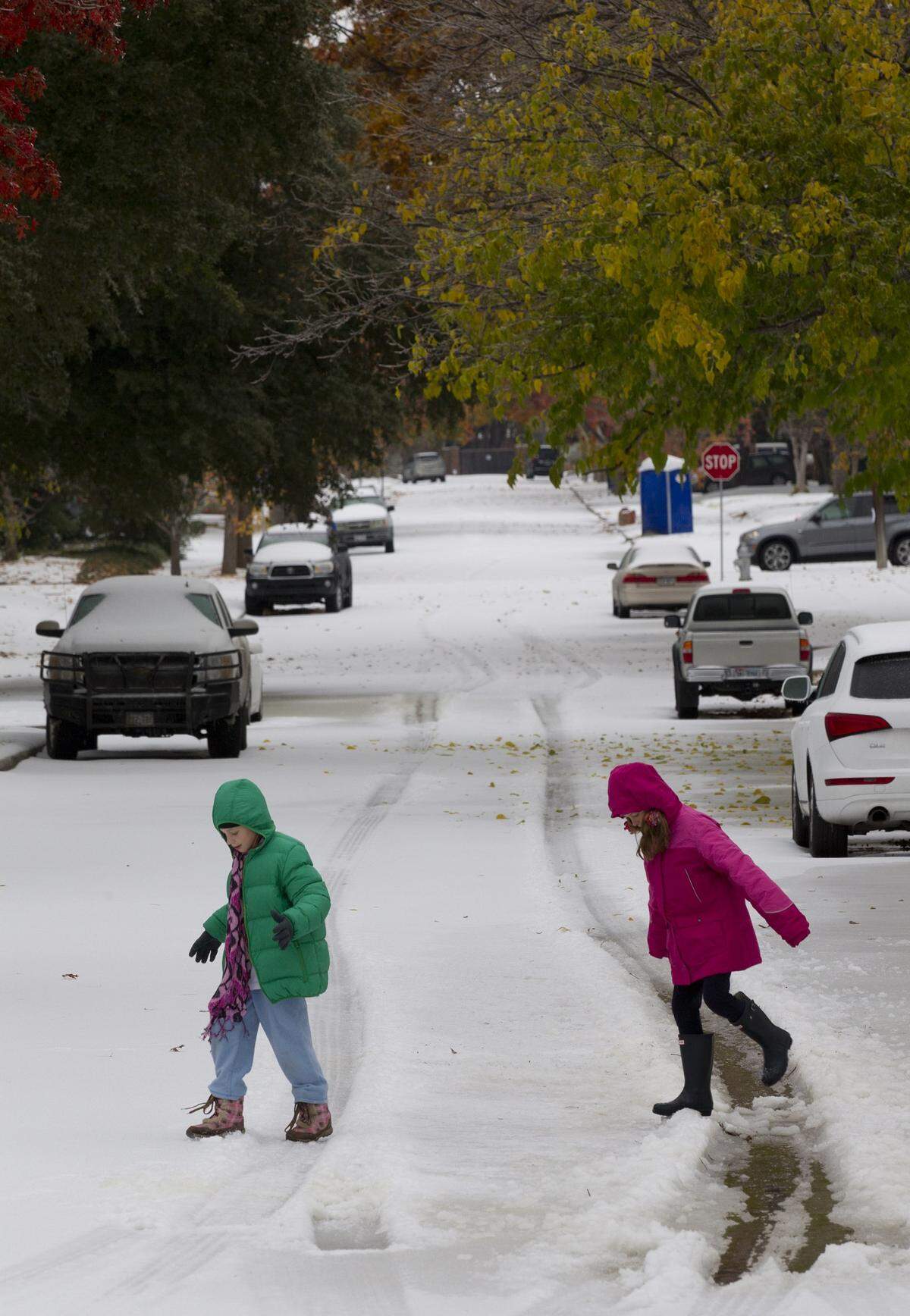 Jamie Hannah, 9, and Emily Bell, 11, play in the ice in west Fort Worth on Friday, Dec. 6, 2013.