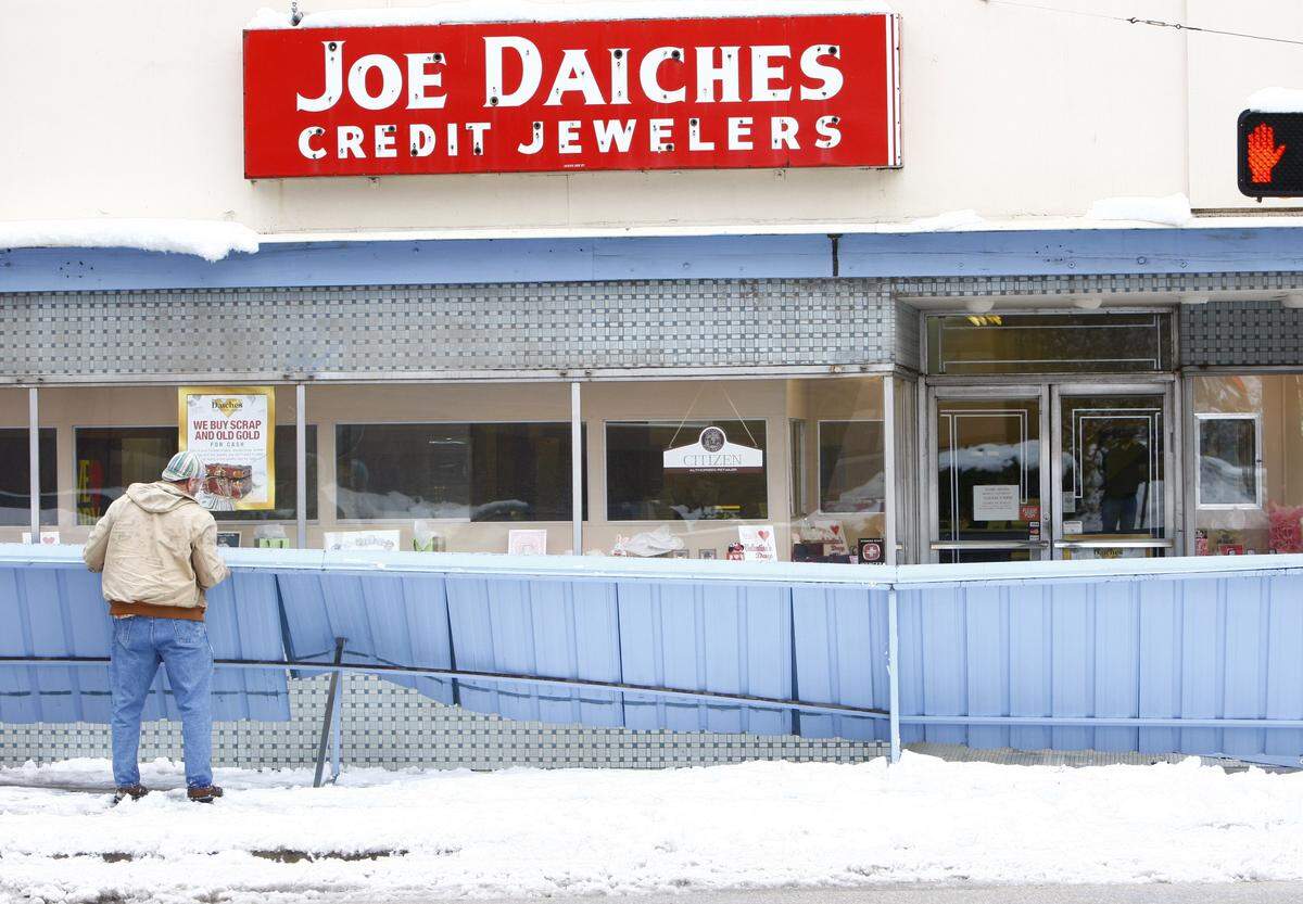 Hans Vatter works to disassemble and remove an awning that fell Friday, February 12, 2010, at Joe Daiches jewelry store in downtown Fort Worth, due to the weight of record snowfall.