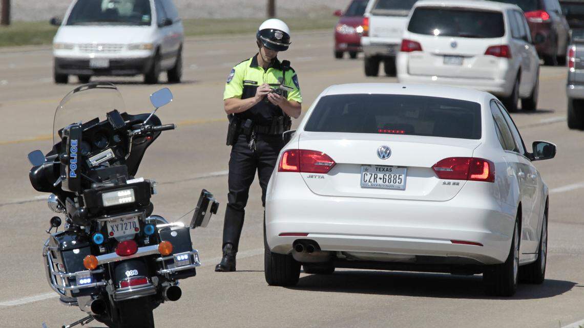 In this file photo, a Keller traffic officer tickets a driver for speeding along U.S. 377.