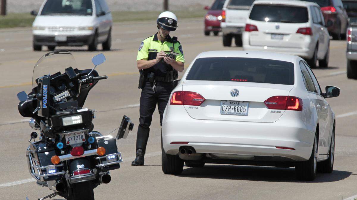 Traffic officer Stephen Grossman tickets a motorist for speeding along Hwy 377 in Keller, Texas on Tuesday, March 25, 2014.  The department is trying to Tweet the officer's location to allow motorists to slow down and avoid citations.   (Star-Telegram/Ron T. Ennis)  