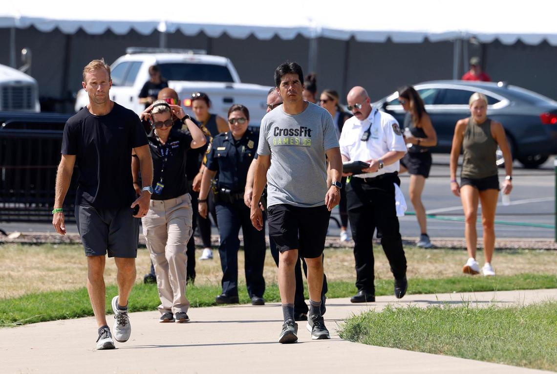 CrossFit CEO Don Faul, left, and Dave Castro, director of CrossFit Games, walk to a press conference followed by emergency personnel after an athlete drowned in Marine Creek Lake on Thursday, August 8, 2024, during the run swim event.
