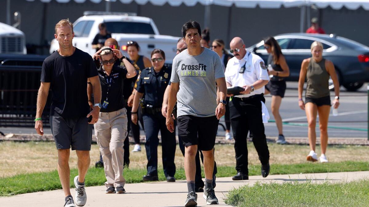 CrossFit CEO Don Faul, left, and Dave Castro, director of CrossFit games walk to a press conference followed by emergency personnel after an athlete drowned in Marine Creek Lake on Thursday, August 8, 2024, during the run swim event.