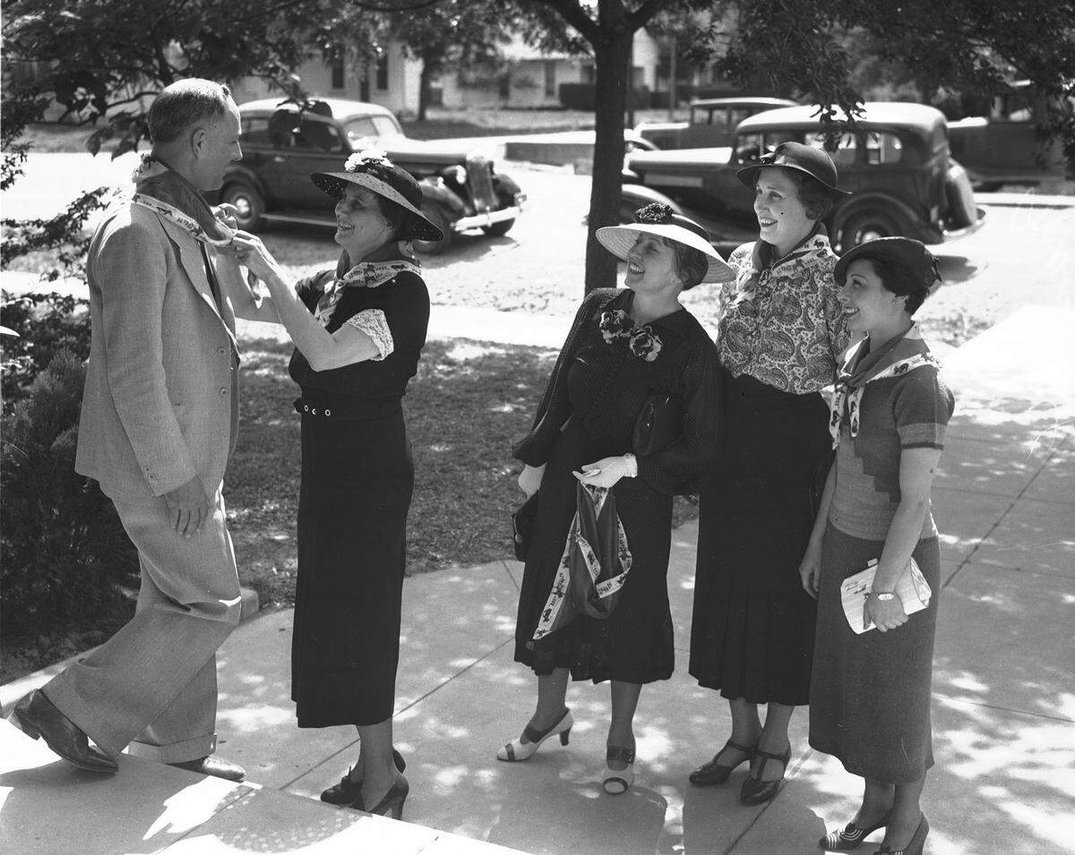 May 14, 1936: Women’s goodwill tour to Weatherford on behalf of Fort Worth Frontier Centennial; Mrs. Edwin T. Phillips ties cowboy kerchief on R.G. Boger, president of Weatherford College. From left, Mrs. Whitehead, Miss Lotspeich, and Charlotte Max.