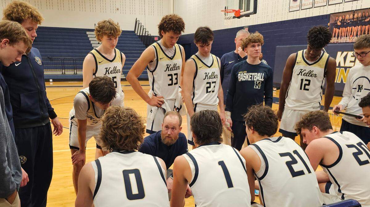 Keller head coach Zach Weir, kneeling center, instructs his team during a time out against Keller Timber Creek in a District 4-6A basketball game on Tuesday, January 28, 2025 at Keller High School.