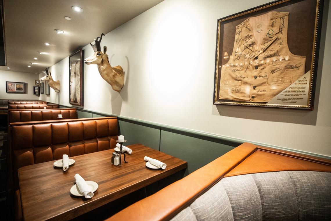 A light of booths with wall decorations Friday, July 19 at Reata Restaurant in the Tower. The vest was signed by Reata employees during the closing of the previous location in 2001.