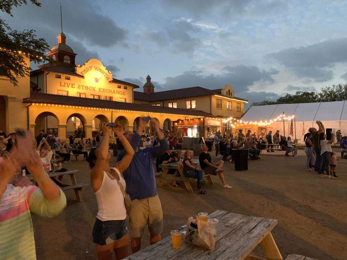 Fort Worth Stockyards stargazers whoop, cheer and gasp as the sky blackens during the solar eclipse totality on Monday, April 8, 2024.. A fair few booed when clouds temporarily blocked out the spectacle. 