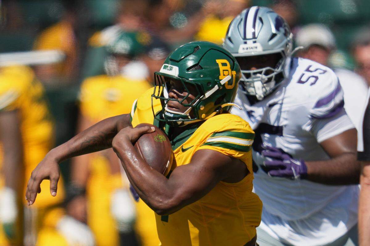 Oct 4, 2025; Waco, Texas, USA; Baylor Bears running back Bryson Washington (7) runs with the ball against Baylor Bears linebacker Jaylin Jones (55) during the first half at McLane Stadium. Mandatory Credit: Chris Jones-Imagn Images