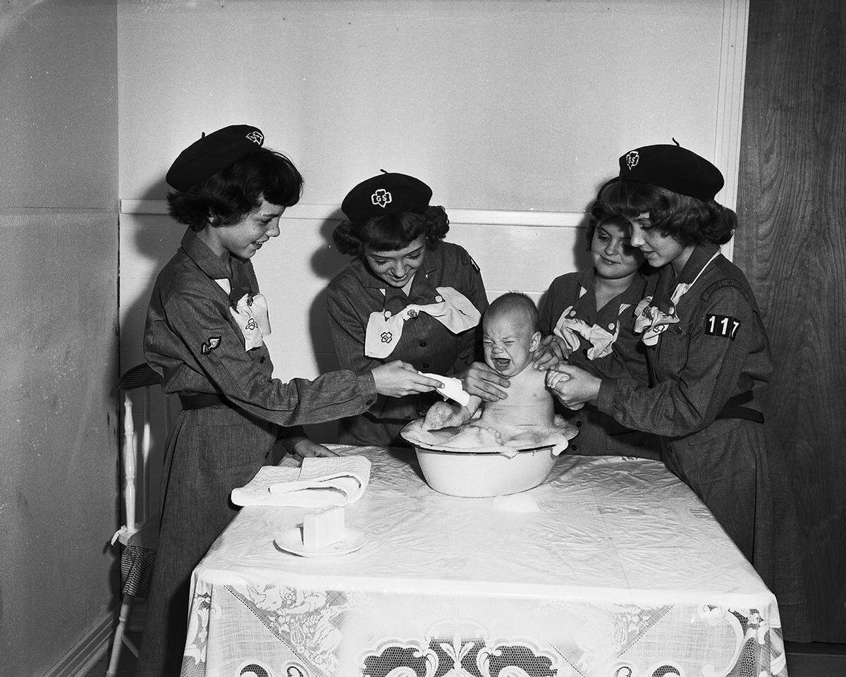 Oct. 3, 1951: Larry Bussey, 4-month-old son of Mr. and Mrs. Brannon Bussey Jr. of 2113 Glencrest Drive, expresses disapproval of his bath at the hands of four girl Scouts who are learning child care. Frances Bussey, Dalene Earnheart, Brenda Gunter and Barbara Maddux, left to right, are members of the Community Chest agency which needs $22,092 for 1952 operations.