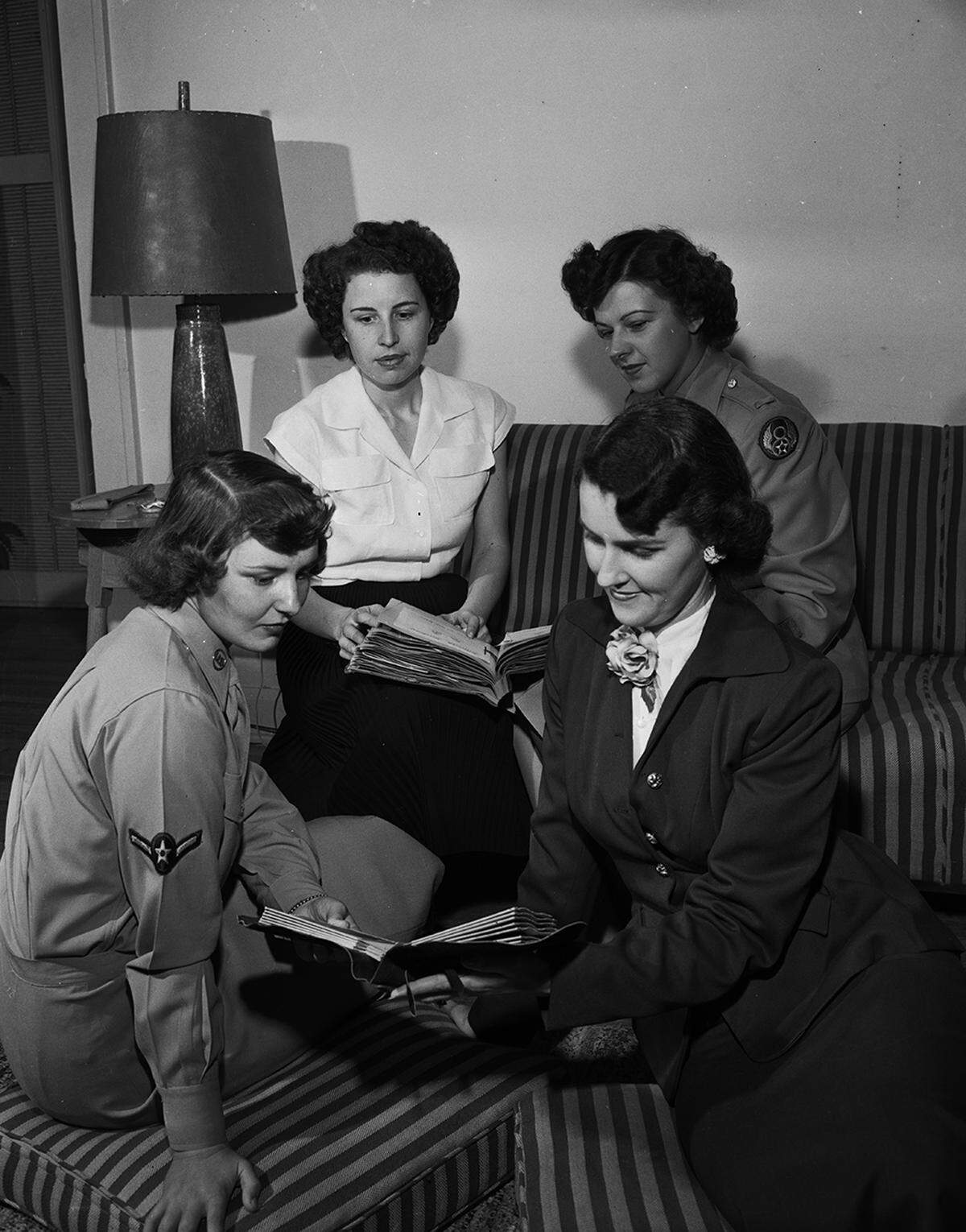 1950: Miss Marguerite Davis, left, president of Beta Alpha Rho, business girls’ club, and Lieutenant Delores Knapik, WAF squadron commander at Carswell Air Base, watch as Mrs. Connie Pickens, lower right, shows Beta Alpha Rho literature to Private officer Marcella Grossman. The WAFs from Carswell were guests at a Beta Alpha Rho banquet.