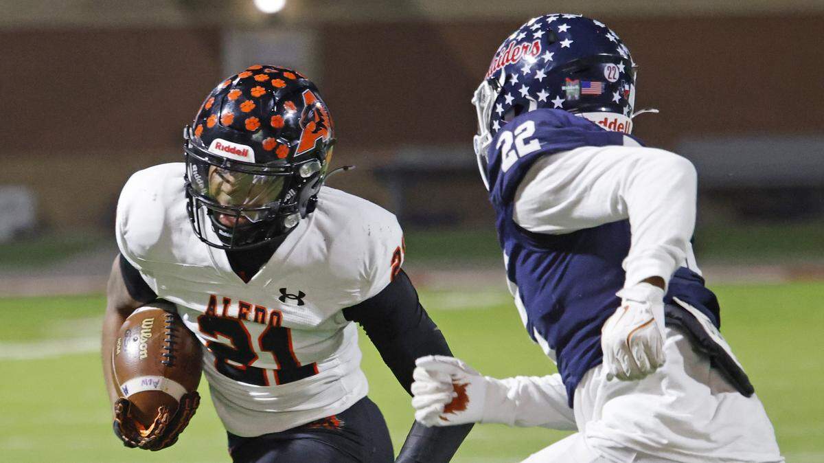 Aledo running back Kaden Winkfield (21) out runs Denton Ryan defensive back Kam Martin (22) for the corner during the first half of a UIL Class 5A Division I Quarterfinal on Friday Dec. 05, 2025 at Northwest ISD Stadium in Fort Worth, Texas.