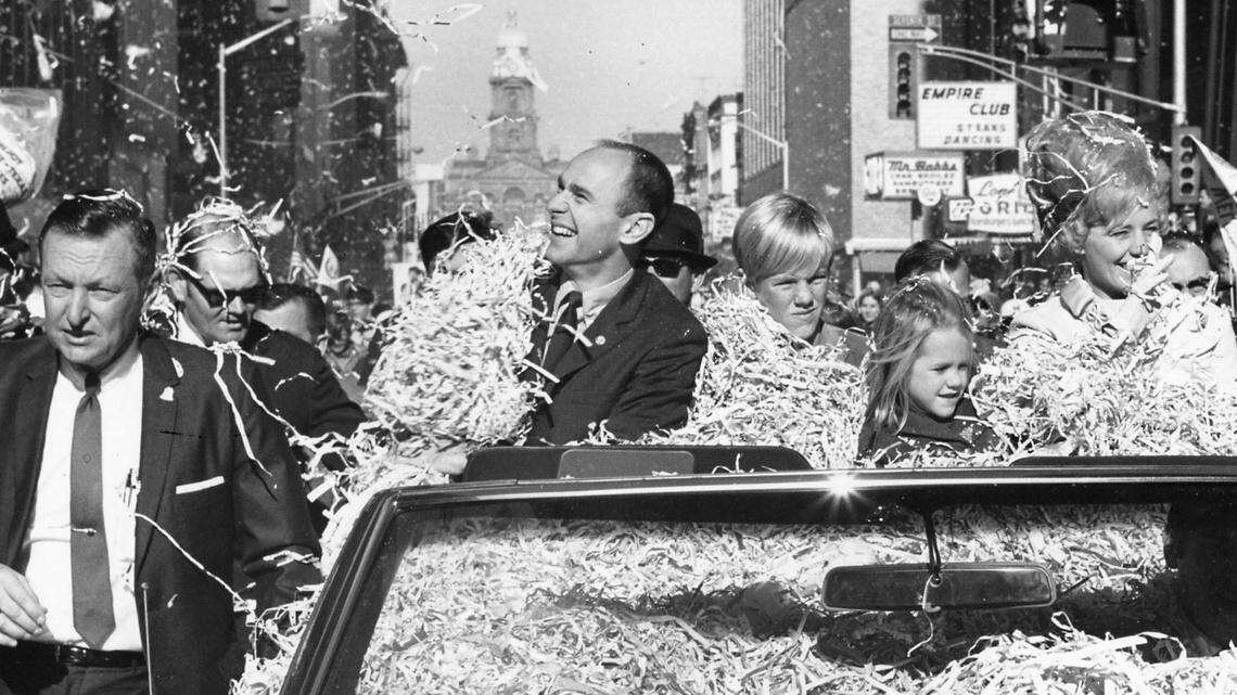 Fort Worth Police Sgt. Jim Stout, a friend, runs beside the car carrying Alan Bean, his wife, Sue, and their son and daughter during the Alan Bean Day Parade in Fort Worth in December 1969.