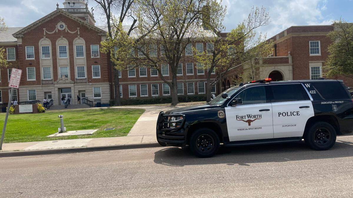 A Fort Worth police car is stationed outside Arlington Heights High School after a false report of a shooting on Thursday, March 23, 2023.