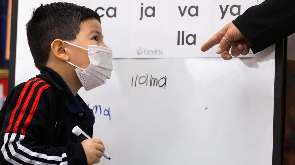 Nicolas Menez looks up at his teacher after writing on the board in his bilingual class at M. H. Moore Elementary in Fort Worth. Students learn in English and Spanish to reach proficiency in both.