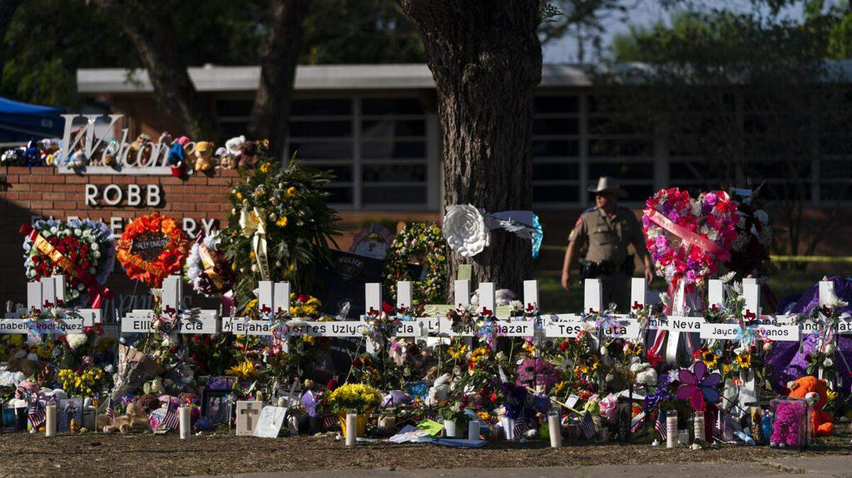 FILE - Flowers and candles are placed around crosses on May 28, 2022, at a memorial outside Robb Elementary School in Uvalde, Texas, to honor the victims killed in the school shooting a few days prior. (AP Photo/Jae C. Hong, File)