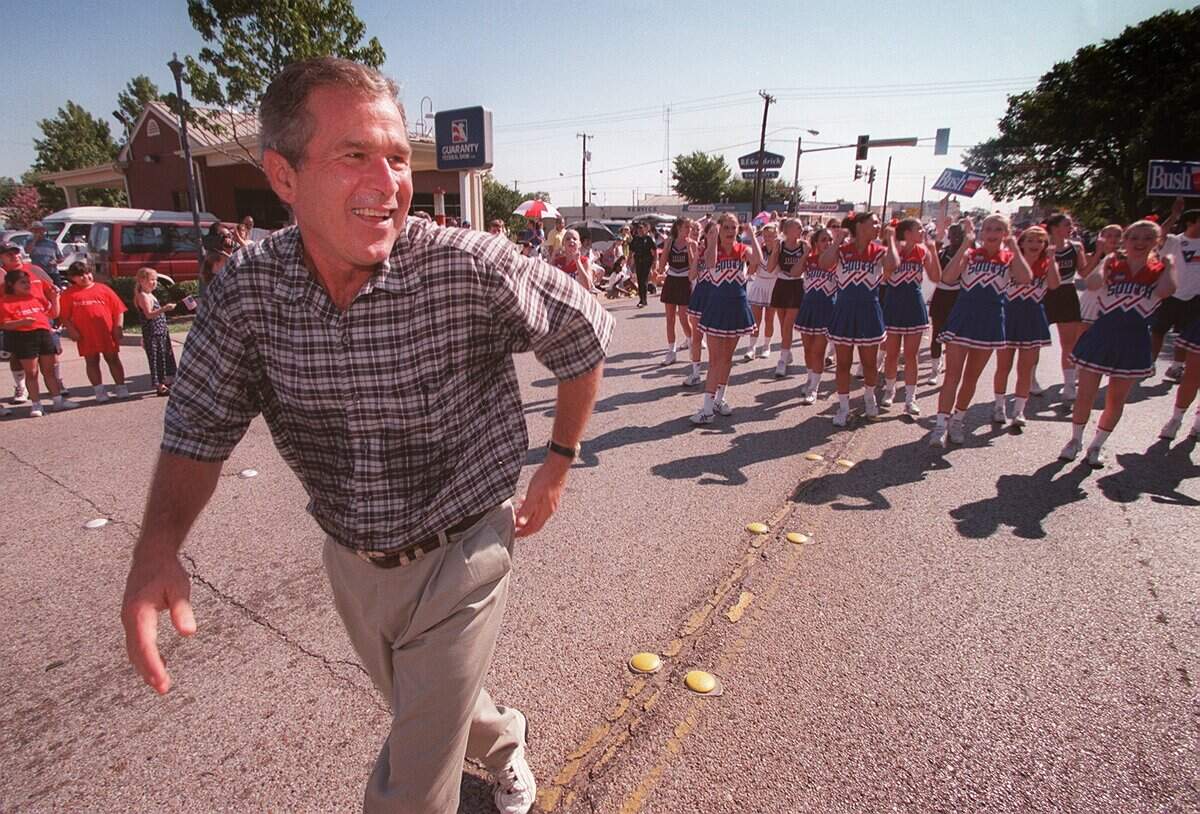 Sept. 7, 1998: Texas Gov. George W. Bush shows some sweat as he walks the Garland Labor Day Parade with support from the South Garland High School cheerleading squad.