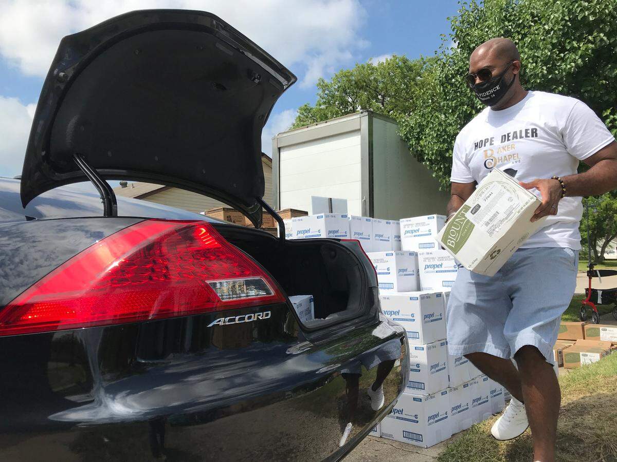 The Rev. Melvin Wilson Jr. of Baker Chapel AME in Fort Worth, TX loads a box of food into a car on Saturday. He said the church has been giving out free food and water, in partnership with Community Food Bank, since the historic winter storms passed in February.