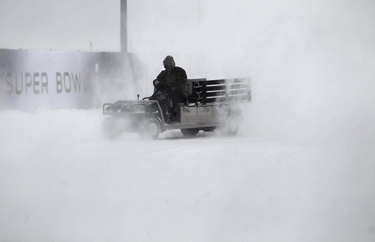 ESPN crewman Anthony Avila navigates his cart through blowing snow proidced by blowers clearing the sidewalks around Cowboys Stadium, site of Super Bowl XLV. About 4 inches of snow fell since overnight, Friday, February 4, 2011. (Tom Fox/The Dallas Morning News)