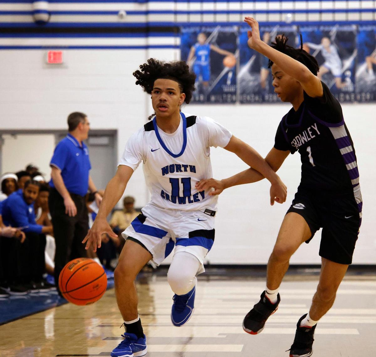 North Crowley guard Isaak Hayes (11) brings the ball down court defended by Crowley shooting forward Jayden Croomes (1) during the first period of a UIL basketball game at North Crowley High School in Fort Worth, Texas, Tuesday, Feb. 13, 2024.