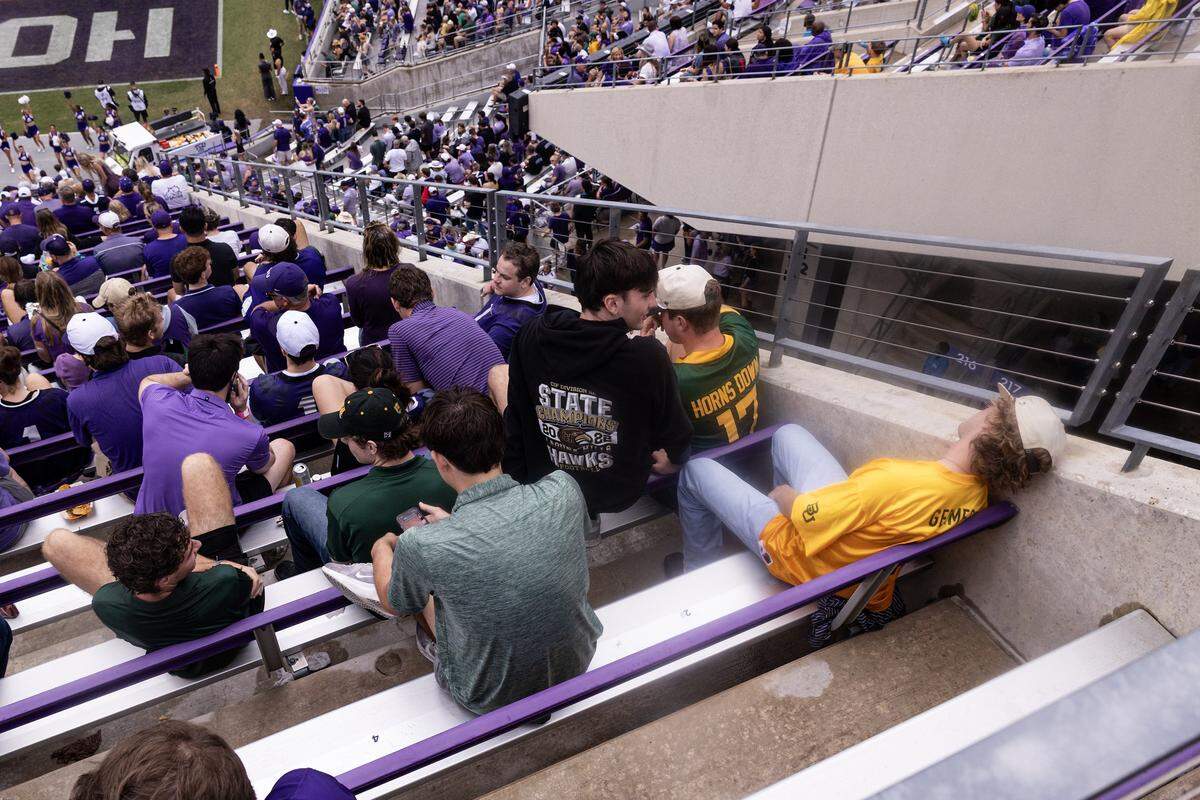 A Baylor fan falls asleep at his seat during the first weather delay in the second half of a Big XII football game between the TCU Horned Frogs and the Baylor Bears at Amon G Carter Stadium in Fort Worth on Saturday, Oct. 18, 2025.