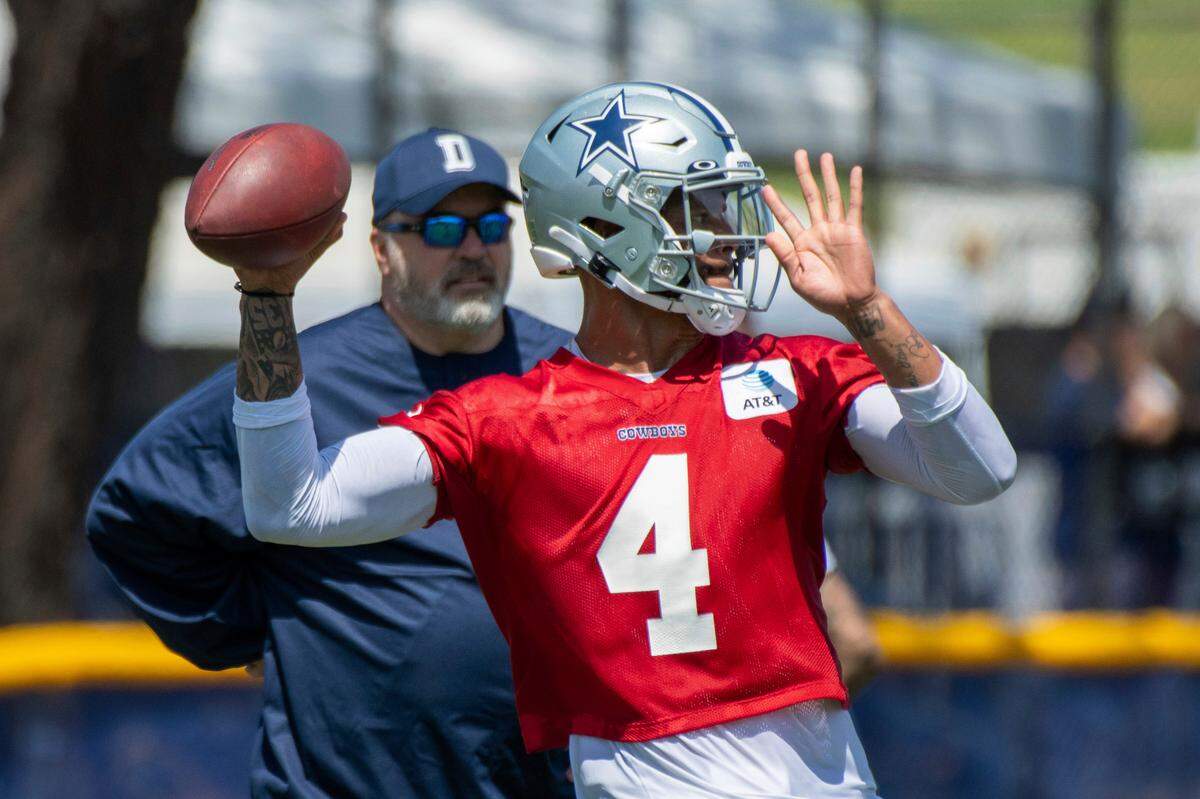 Dallas Cowboys quarterback Dak Prescott throws a pass as coach Mike McCarthy watches during the NFL football team’s training camp in Oxnard, Calif.,on July 21, 2021.