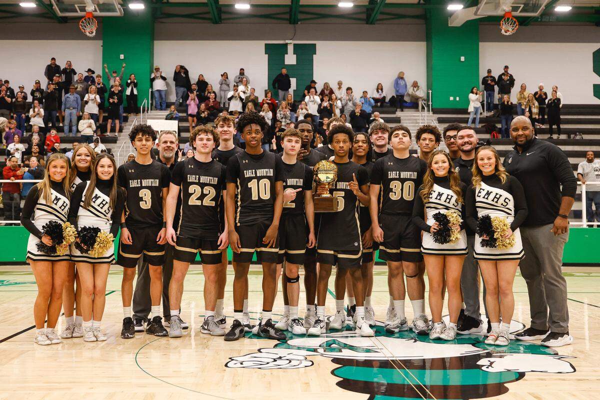 The Eagle Mountain Knights pose with the trophy after winning the first boys basketball playoff game in the school’s debut season against Benbrook in a Class 4A Division 2 bi-district game on Monday, February 17, 2025 at Azle High School. Eagle Mountain won 60-48.