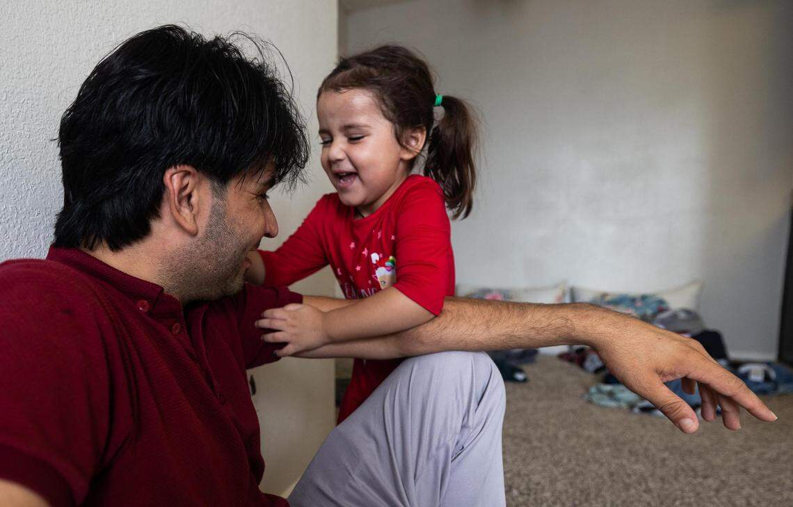 Basir Khan’s 2-year-old daughter, Khatira, tries to get his attention to play in their Fort Worth home.
