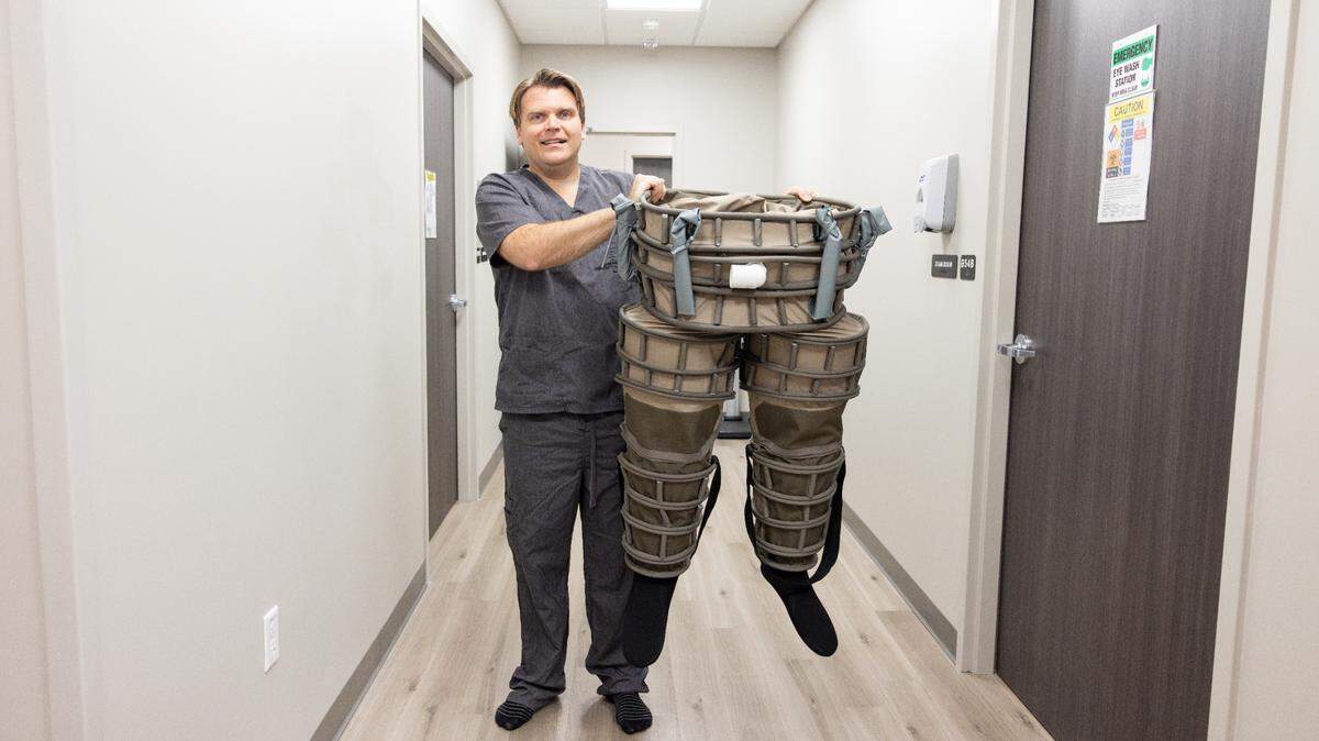 Dr. Nelson holds up new lower-body negative pressure pants at UTA’s Clinical Imaging Research Center. The pants were made with the help of graduate student Brandon Hathorn.