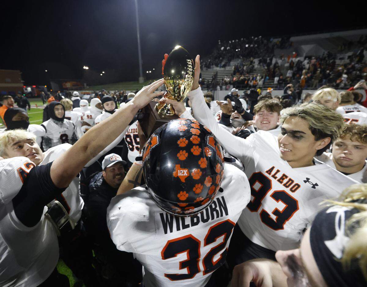 The Aledo Bearcats celebrate with the trophy after defeating Denton Ryan in a UIL Class 5A Division I Quarterfinal on Friday Dec. 05, 2025 at Northwest ISD Stadium in Fort Worth, Texas.