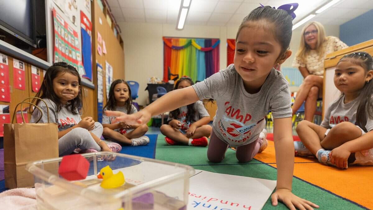 Yamileth Escalera tosses a red foam cube into a container full of water during a pre-K prep program at Castleberry Elementary School in Fort Worth on June 29, 2026. The students had to guess whether their chosen object would float or sink when dropped in water.