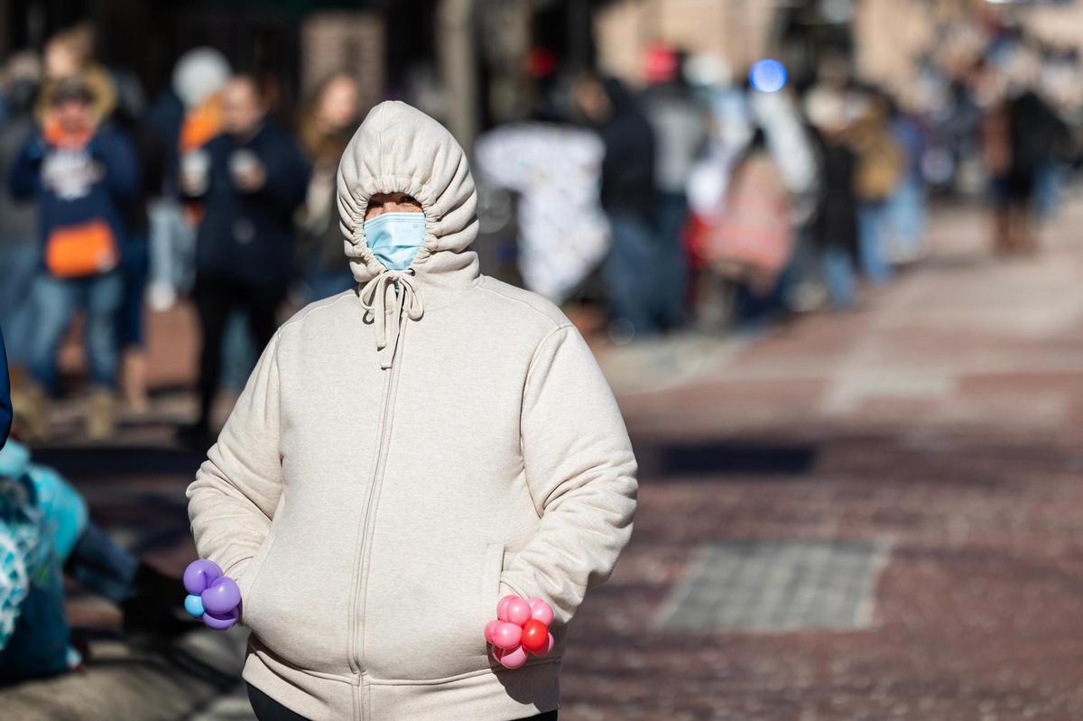 Dallas resident Graciela Piña bundles up with a mask to watch the Fort Worth Stock Show All Western Parade in downtown Fort Worth on Saturday, Jan. 18, 2025.