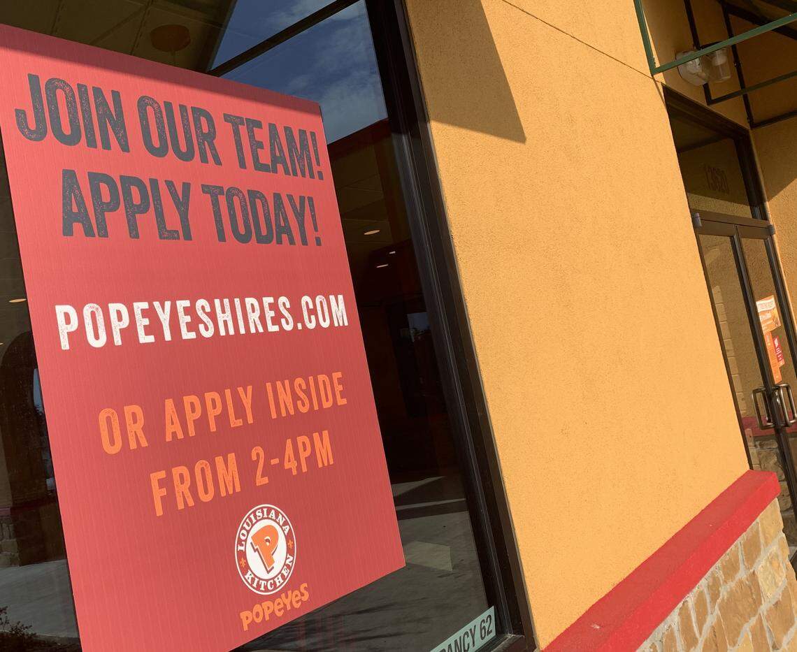 A sign outside a Popeye’s in Northlake urges proespective employees to apply inside.