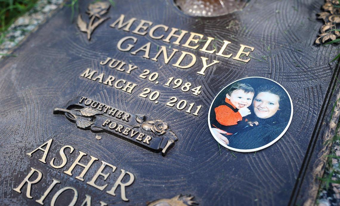 A photograph shows Mechelle Gandy holding her son, Asher, at the site of their grave in Arlington on Thursday, August 25, 2022. Gandy and her son were brutally murdered in 2011. Thomas Olivas was convicted of the crime and sent to prison for life.