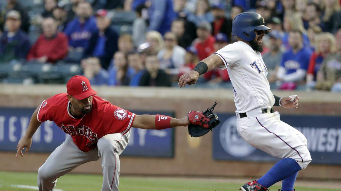 Los Angeles Angels first baseman Albert Pujols attempts to tag out Texas Rangers' Rougned Odor who got back to first safely after Elvis Andrus lined out to right in the first inning Monday. Odor was injured on the play.