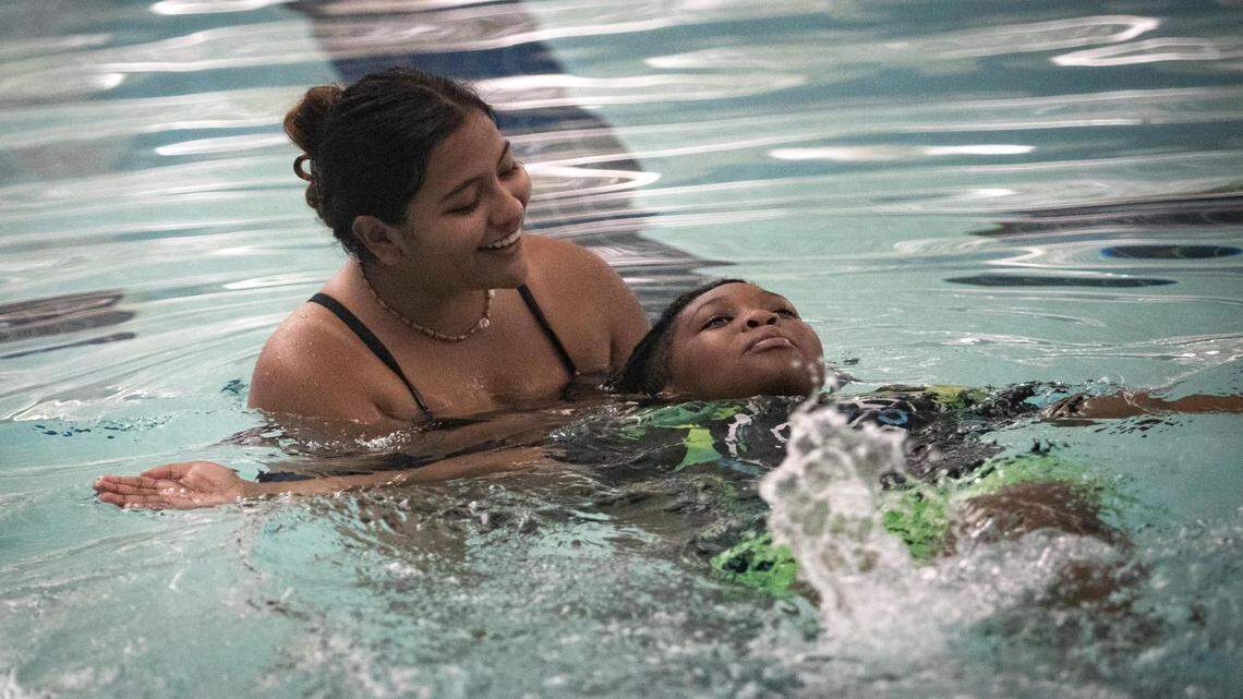 Swim instructor Meredith Garcia floats with Isaiah Cooper as he works on his backstroke, at the FWISD Wilkerson-Greines Activities Center in Fort Worth, Texas, on Thursday, July 14, 2022.