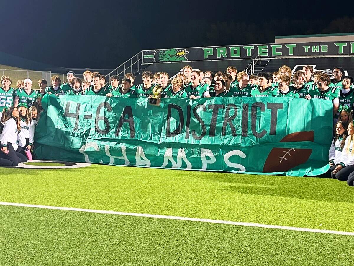 Southlake Carroll football holds a district championship banner Friday at Dragon Stadium in Southlake.