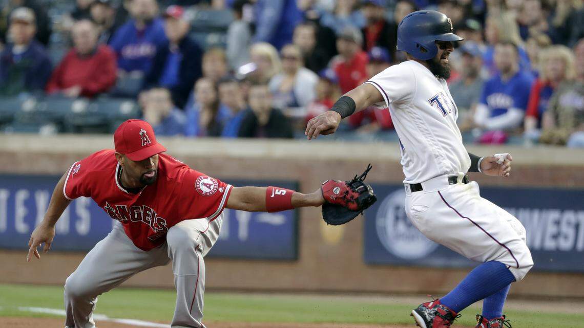 Albert Pujols attempts to tag Rangers' base runner Rougned Odor at first base on Elvis Andrus' line out to right in the first inning Monday. Odor strained his left hamstring on the play and had to leave the game. Jurickson Profar replaced him at second base.