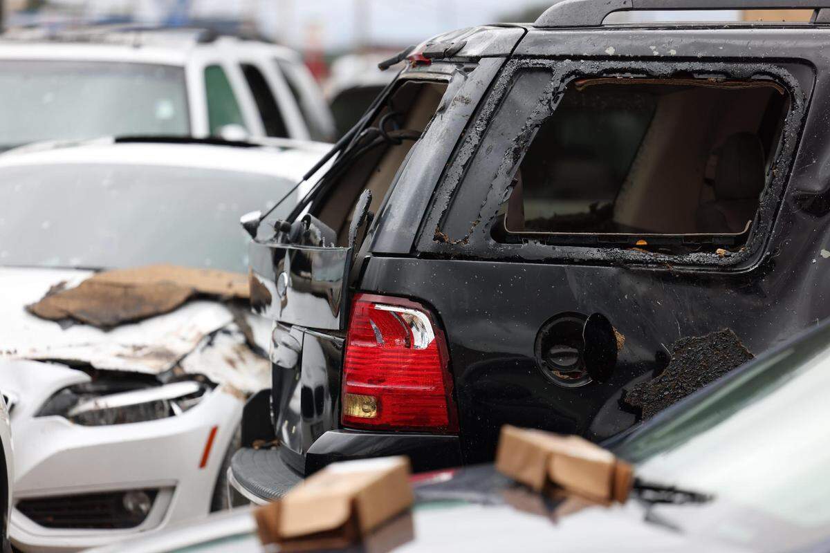 Numerous vehicles at Special Touch Auto Sales can be seen on Thursday, October 5, 2023, after severe thunderstorms swept through the area Wednesday evening in Fort Worth. A roof ripped off a nearby shopping center landed onto the car lot.