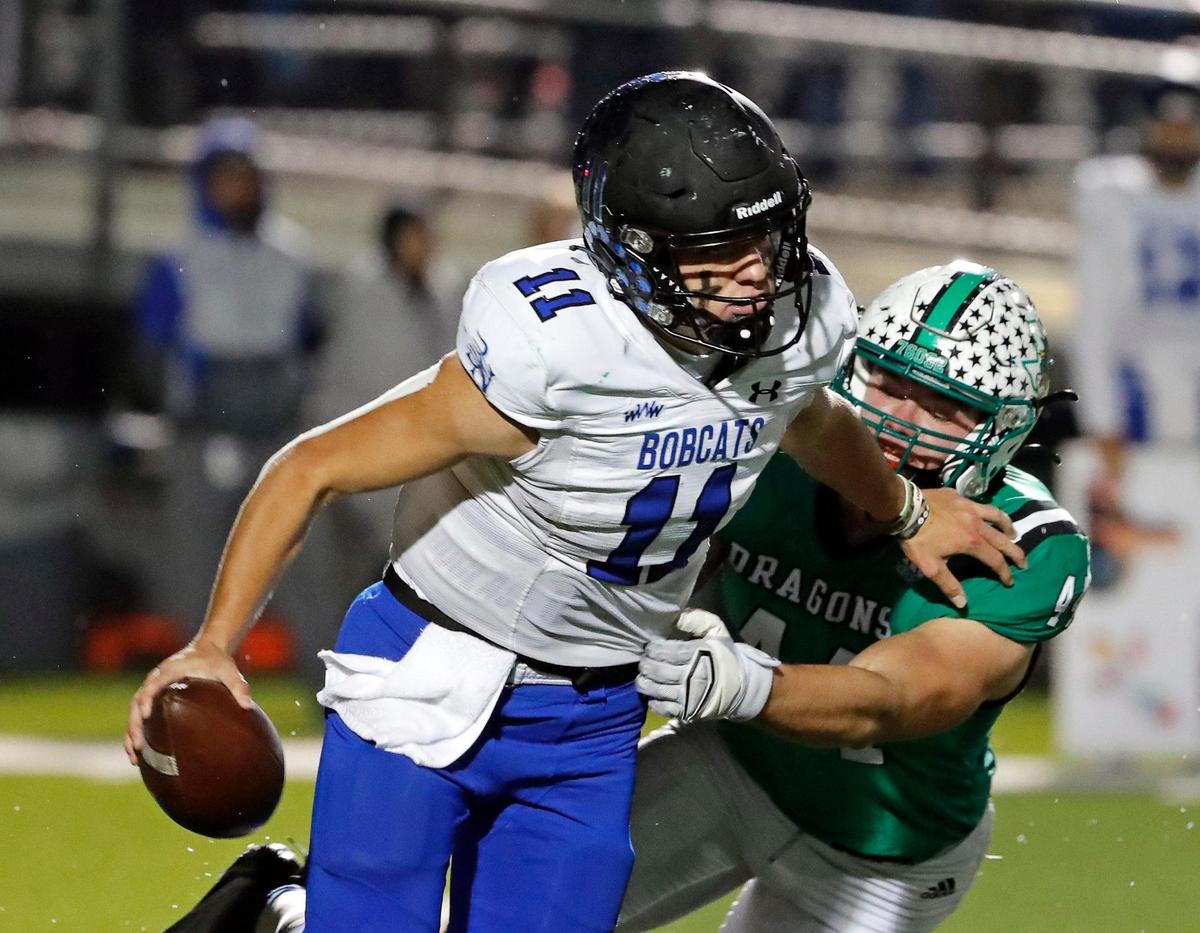 Byron Nelson quarterback Jake Wilson (11) escapes the grasp of Southlake Carroll defensive lineman Dustan Mark (44) in the first half of a District 4-6A football game at Dragon Stadium in Southlake, Texas, Friday, Oct. 28, 2022. Carroll led Byron Nelson 21-13 at the half. (Special to the Star-Telegram Bob Booth)