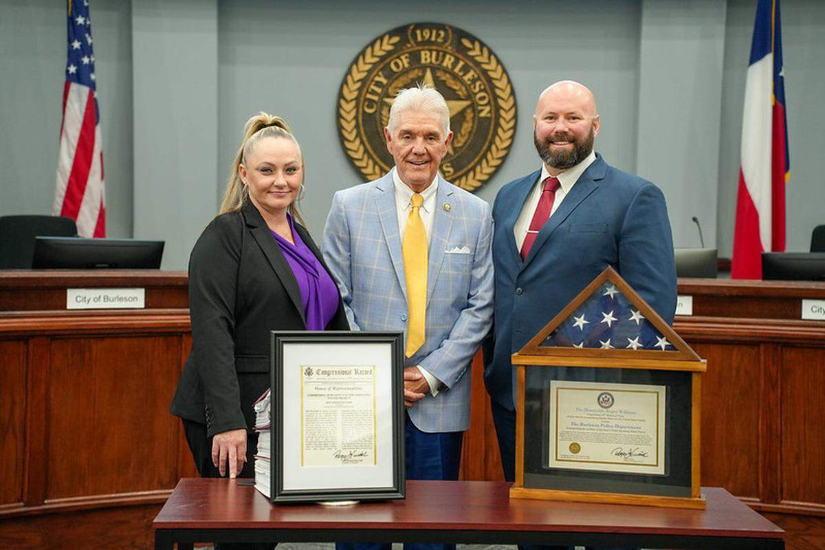 Burleson Police Department Victim Assistance Coordinator Stephanie Beard with U.S. Rep. Roger Williams (center) and Burleson Police Department Communications Coordinator Collin Gregory at Burleson city hall on Aug. 15, 2025. Williams was in Burleson to honor the police department for its Victim Assistance Poster Program.