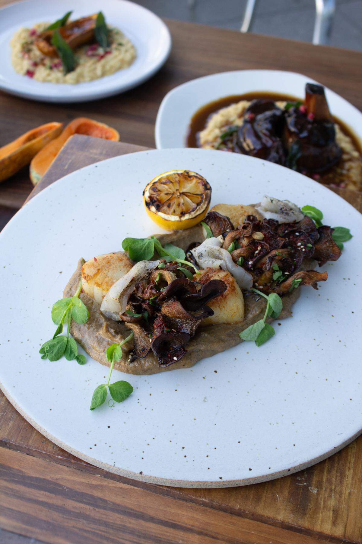 The pan seared scallops from Cafe Modern are topped with lardo, a skimming of fat from a pig’s back.