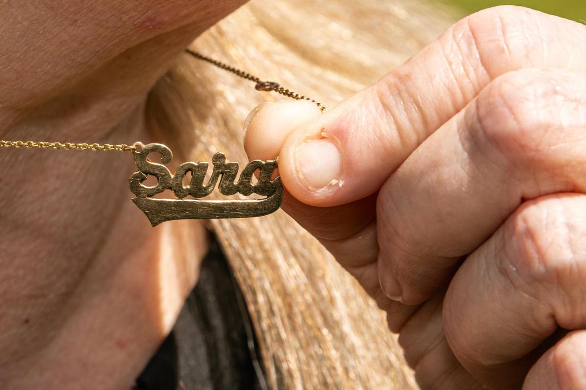 Tricia Hanson wears a necklace in memory of her daughter, Sara, who was a victim of domestic violence.